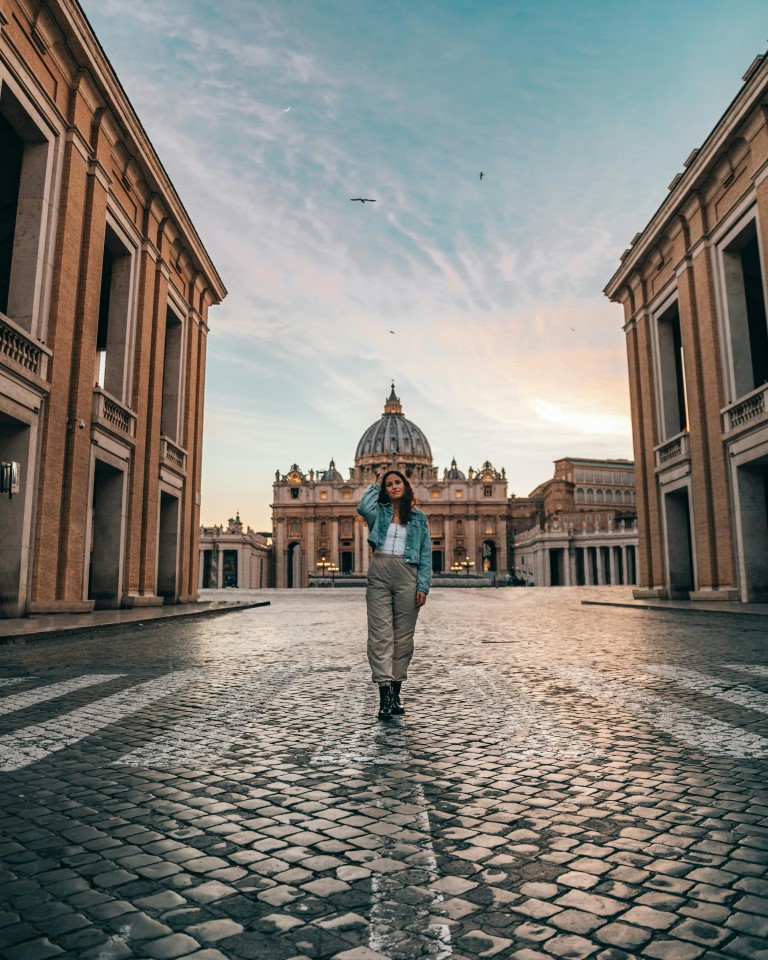 Woman posing in a massive courtyard in Rome.